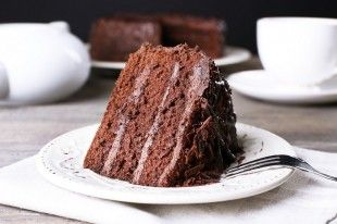 43129338 – delicious chocolate cake in white plate on wooden table , closeup