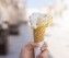 Close up focus of female hand holding melting delicious ice crea