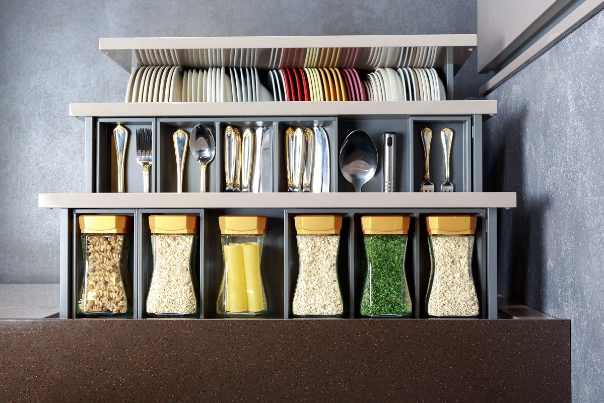 Modern kitchen countertop with food ingredients. Top view of drawers with spices organized inside.