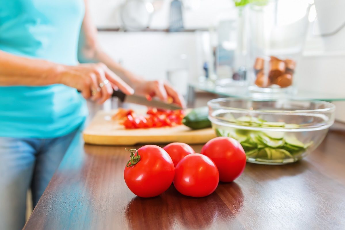 mature woman in the kitchen prepares the meal