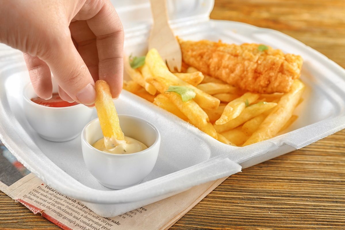 Woman dipping chips into sauce, closeup