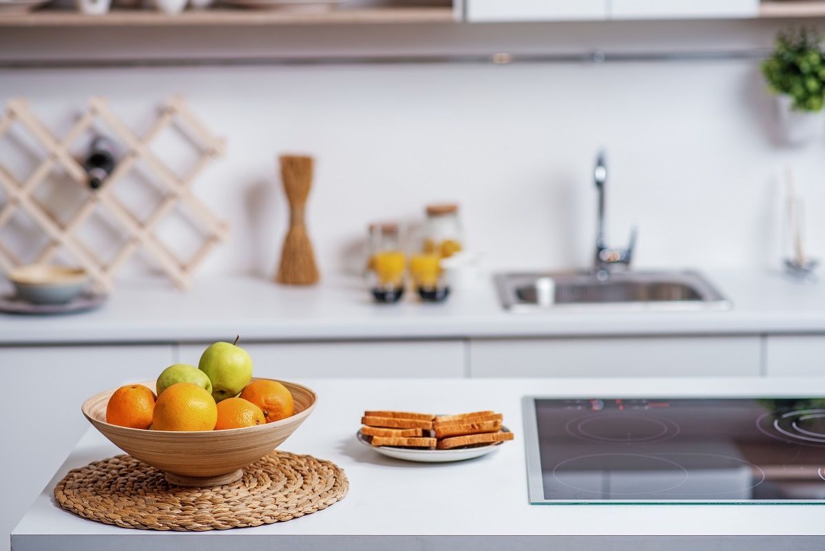 Healthy fruits in plate near electric stove at home