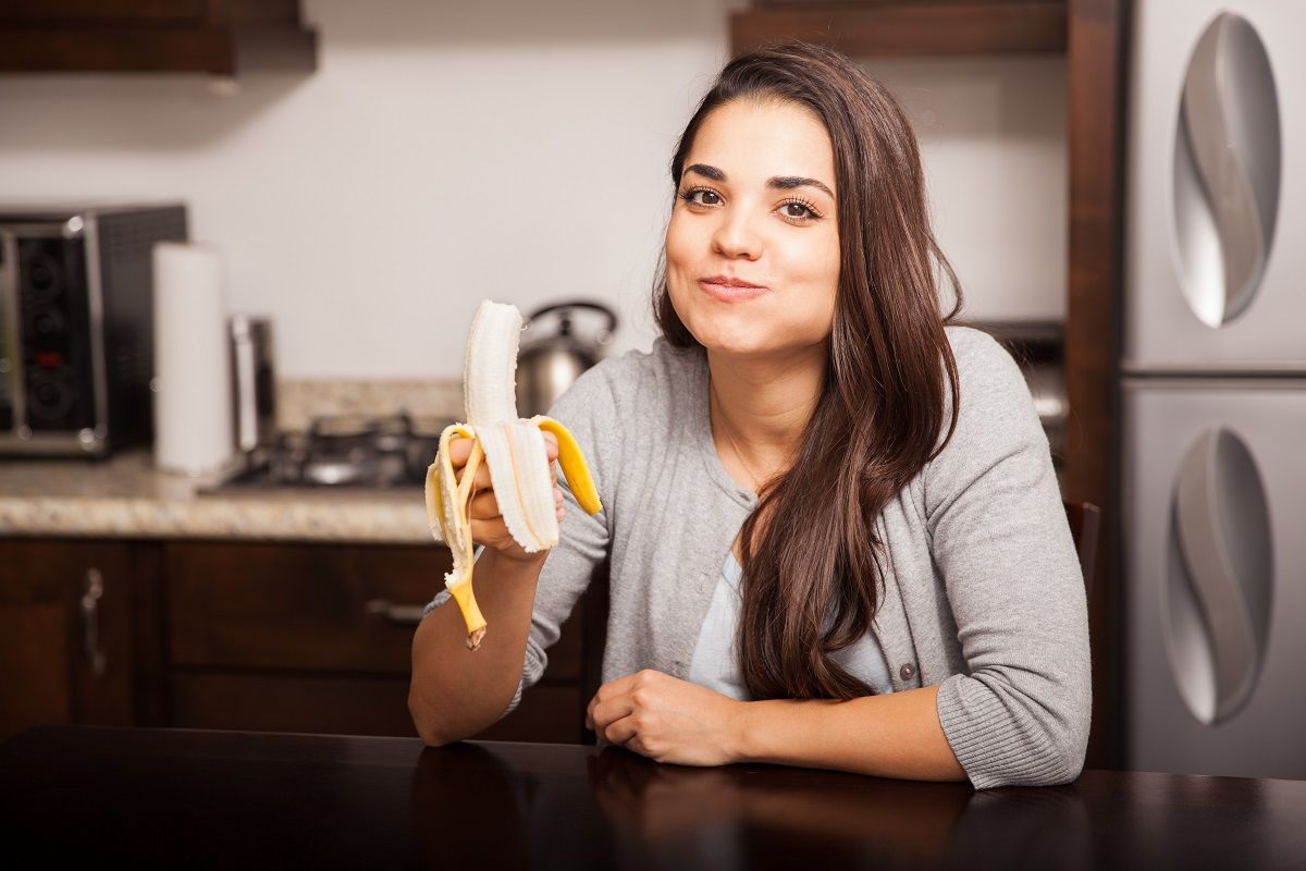 Cute brunette eating a banana