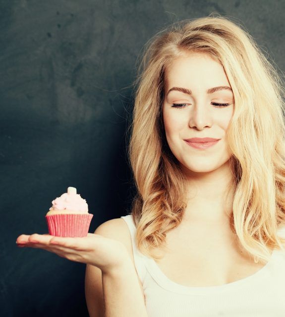 Beautiful smiling young woman with a cake