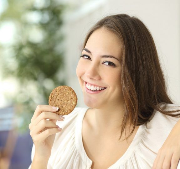 Happy girl showing a dietetic cookie