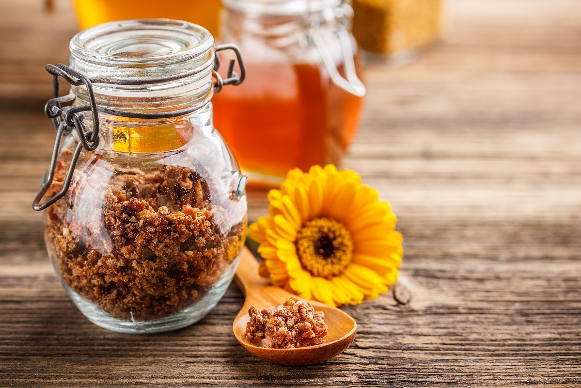 17786744 – propolis granule in glass jar with spoon and flower
