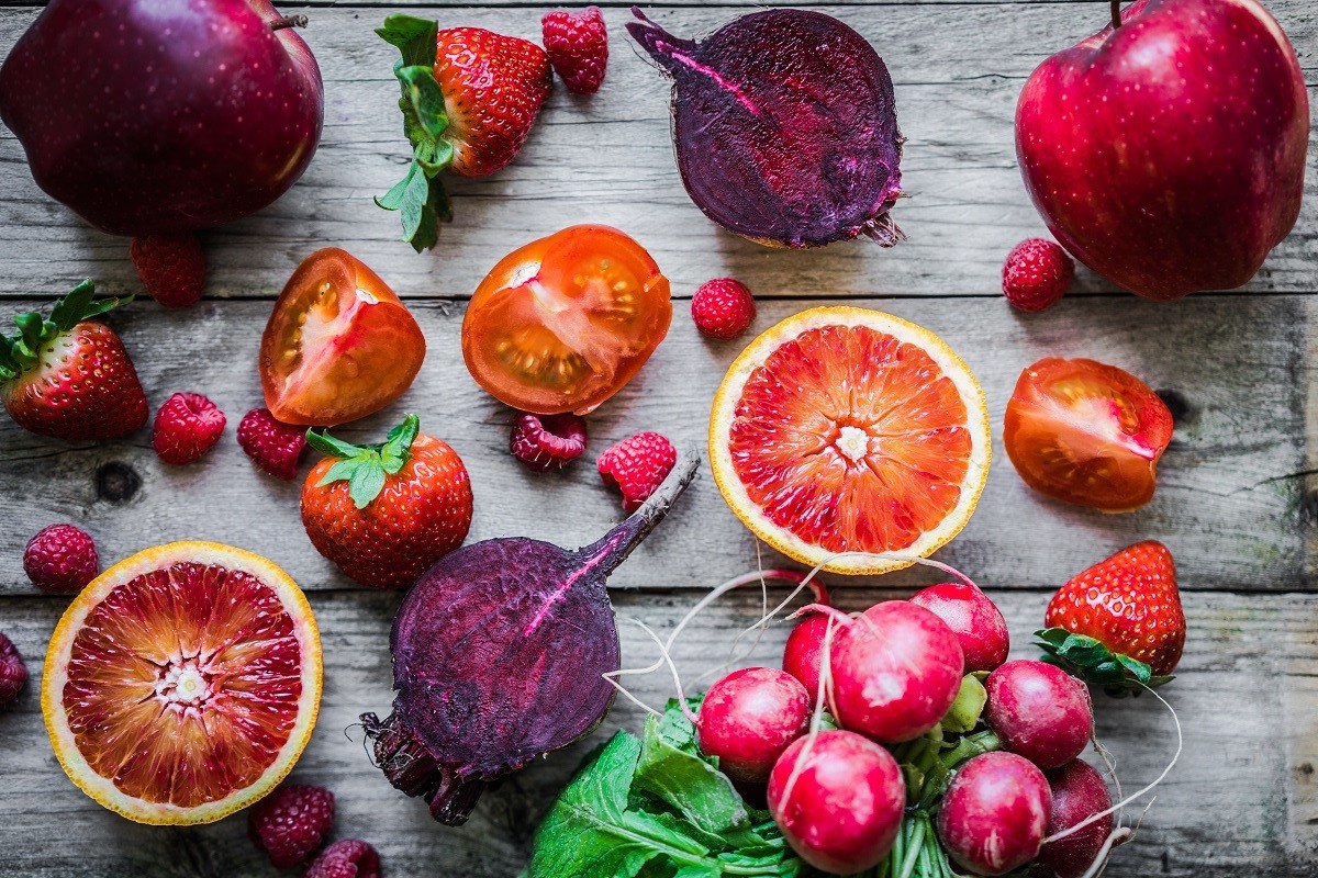 Red fruits and vegetables on wooden background