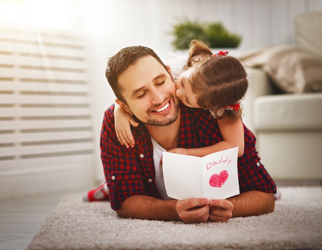 Father’s day. Happy family daughter kiss dad and giving greeting card