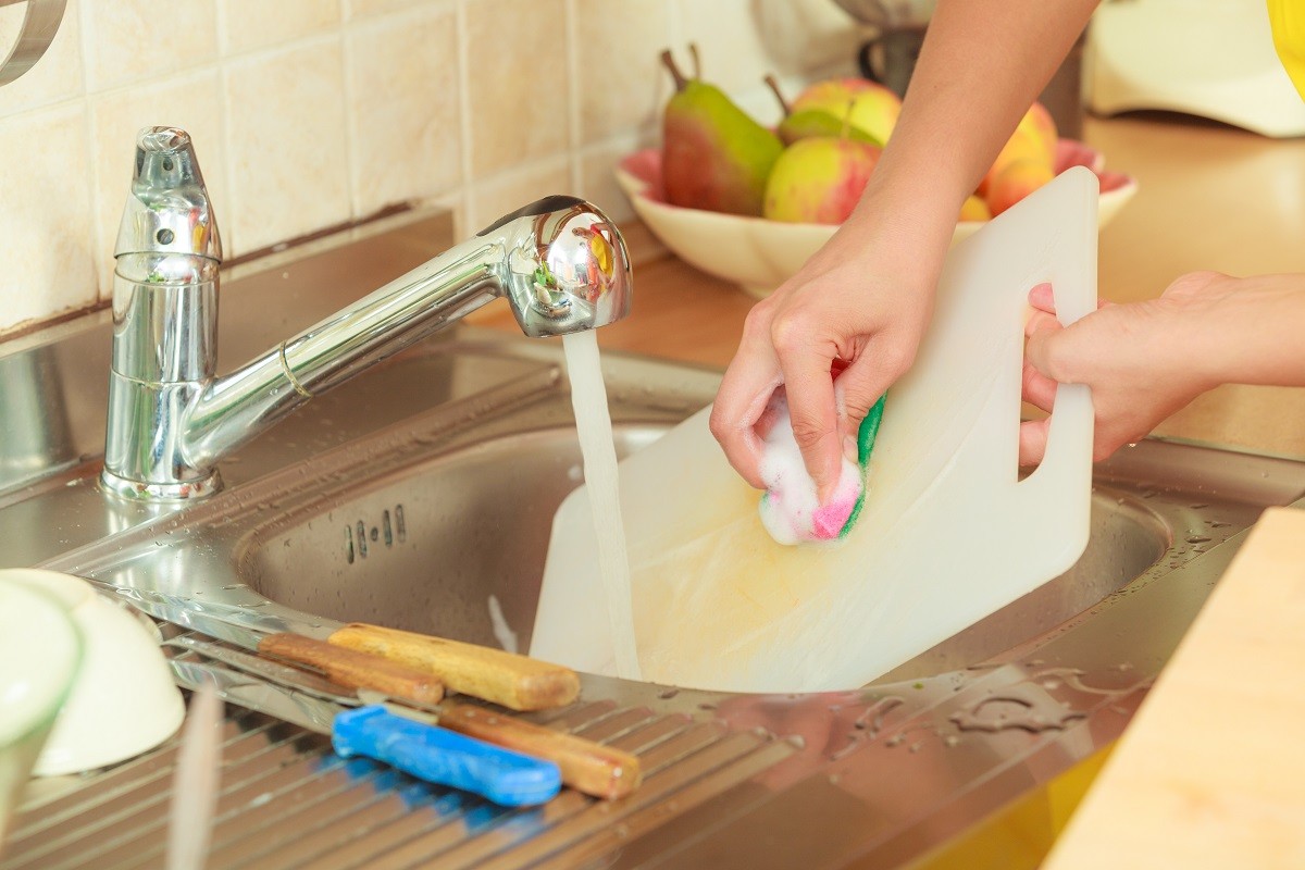 Woman doing the washing up in kitchen