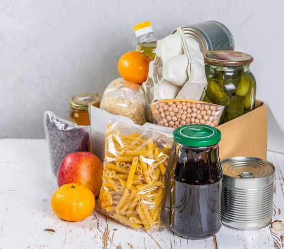 Food donations in box in kitchen background