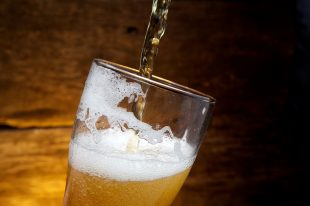 Beer into glass on a old wood