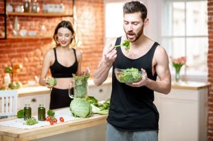 Sports couple eating healthy vegetarian food on the kitchen