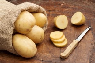 21830440 – raw potatoes and fnife on a wooden background