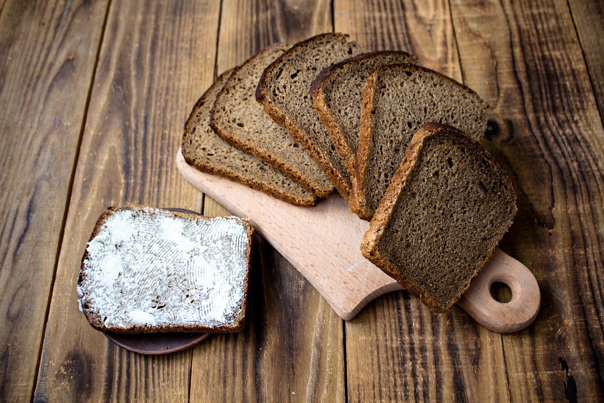 corn bread cut into pieces and butter on a wooden background