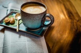 hot latte art coffee with newspaper on wooden table, vintage and