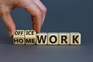 Back to normal. Hand turns cubes and changes the expression ‘home work’ to ‘office work’. Beautiful grey background. Copy space, business concept.