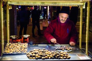 ISTANBUL, TURKEY – DECEMBER 28, 2015: Picture of an old chestnut seller on a cold winter evening on Istiklal street