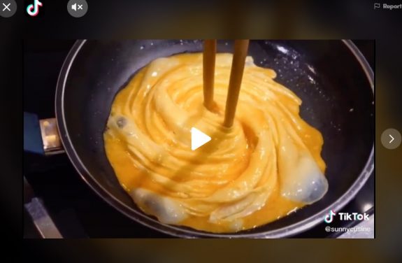 Womann standing in front of opened fridge and holding up to her