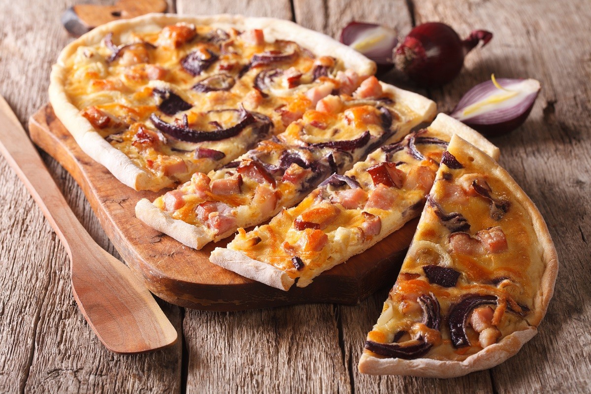 Delicious sliced pie flammkuchen close-up on the table. horizont