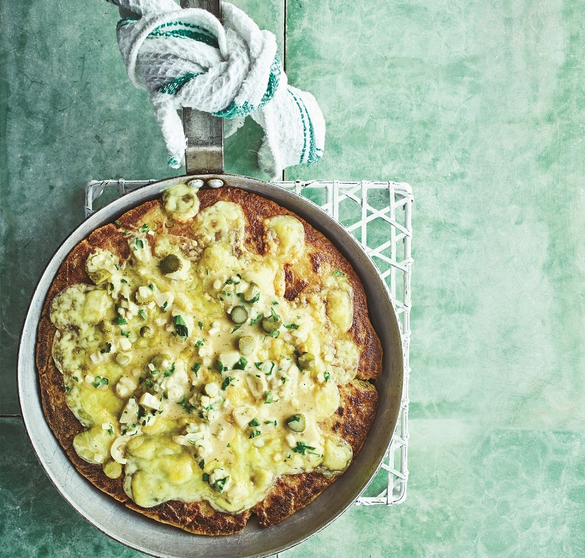 Frying pan potato bread with melting raclette and pickle dressing