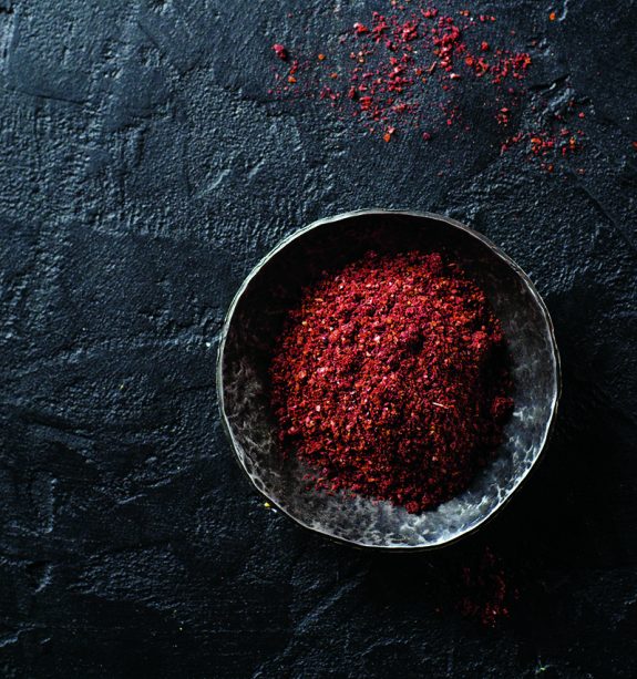 58318896 – sumah or sumak – east spice in metal bowl on dark background.