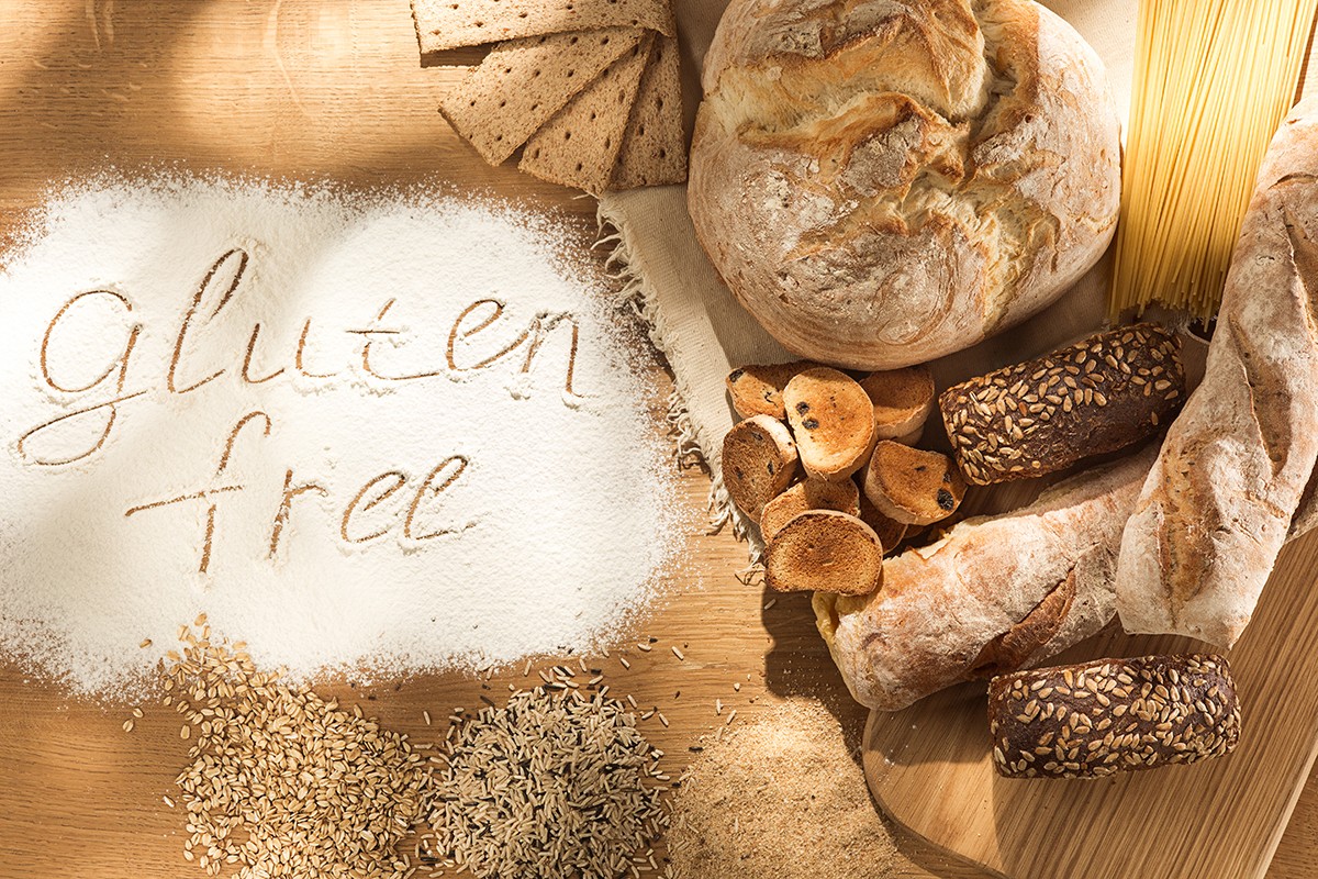 Gluten free food. Various pasta, bread and snacks on wooden background from top view