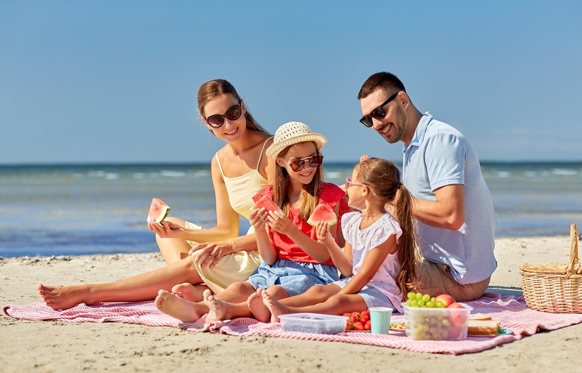 happy family having picnic on summer beach