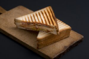 club sandwich on a wooden board on a dark background