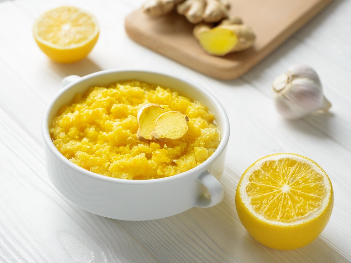 Natural home made remedy that will make immune system stronger and powerful with lemon and ginger with garlic on wooden background