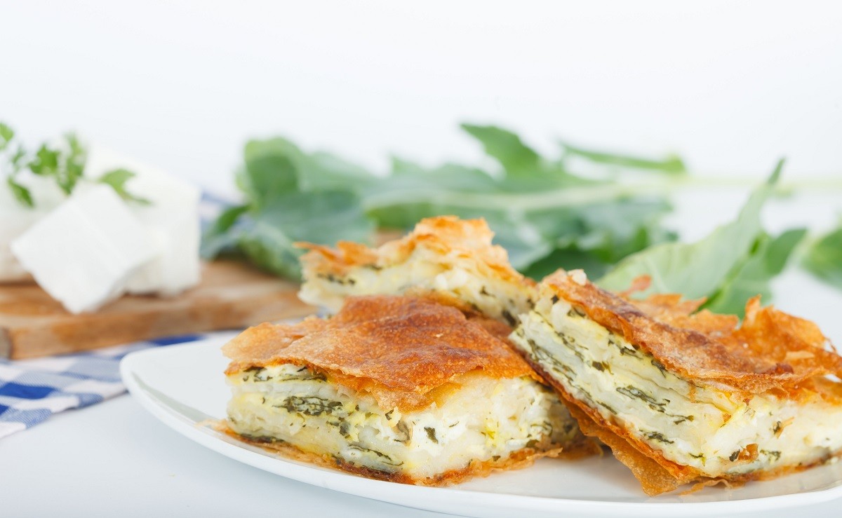 Homemade cheese and spinach pie on a white plate. Shallow depth of field.