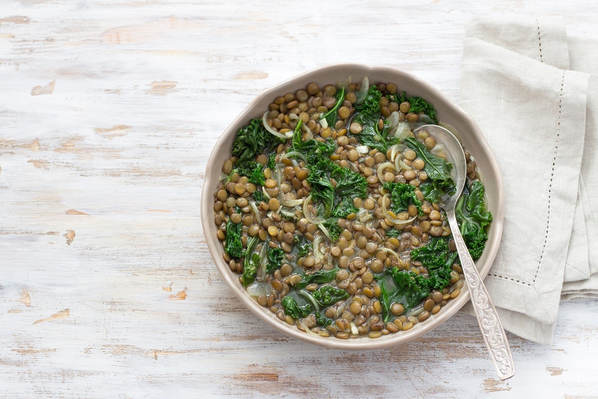 Stewed kale lentils with onions and garlic on a light background