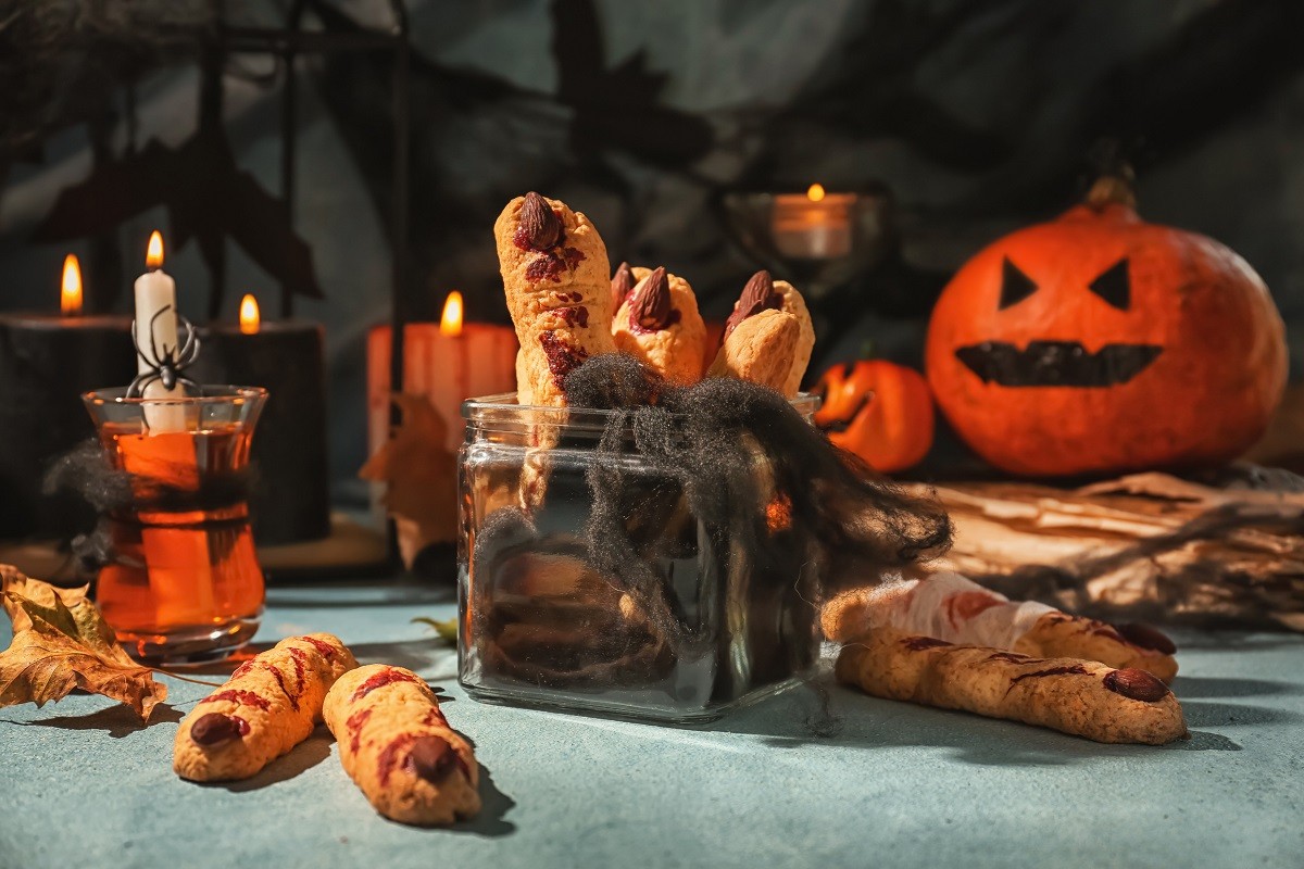 Jar with creative cookies prepared for Halloween party on table