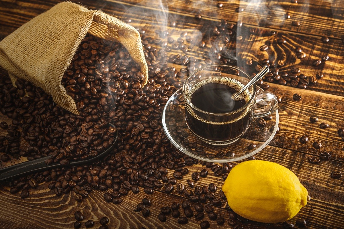 Coffee cup and beans on old kitchen table. Top view with copy sp