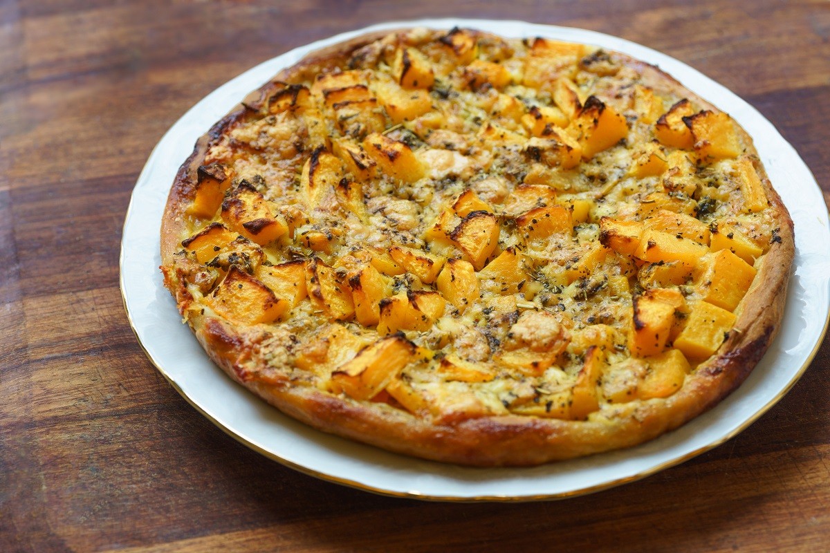 Pizza with pumpkin on wooden background