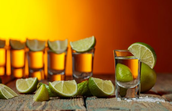 Tequila with  salt and lime on a old wooden background.