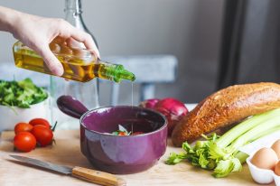 hands of chefs prepare a salad of fresh and healthy ingredients, vegetables and olive oil in the kitchen