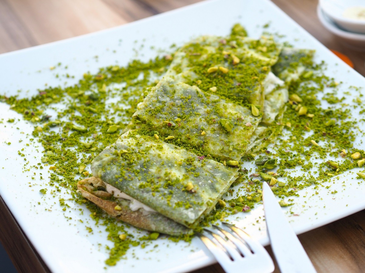 katmer dessert of Turkey Gaziantep region. Prepared with thin dough dessert with ice cream and green pistachio.