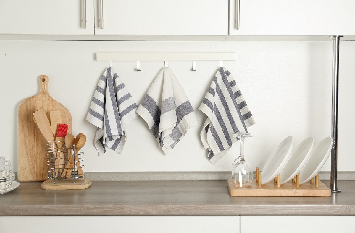 Different kitchen towels hanging on hook rack indoors