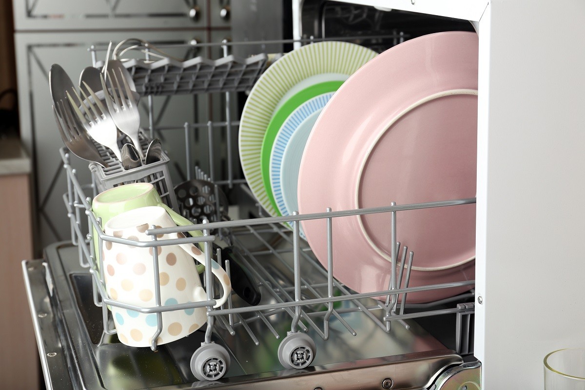 Open dishwasher with clean utensils in it