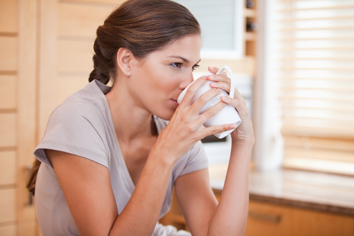 Side view of young woman drinking coffee