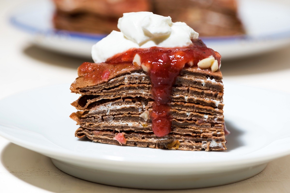 piece of pancake cake with whipped cream and jam