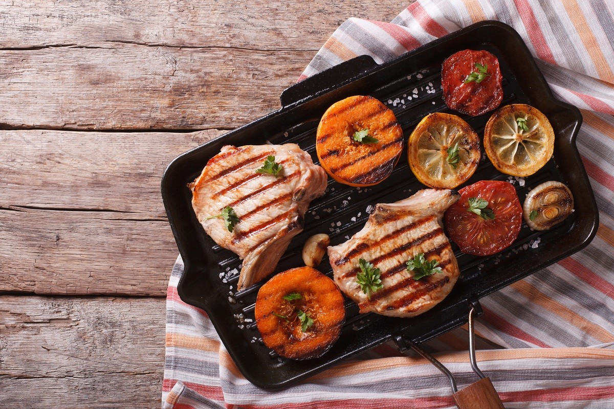 Grilled pork and pumpkin on a grill pan. Horizontal top view
