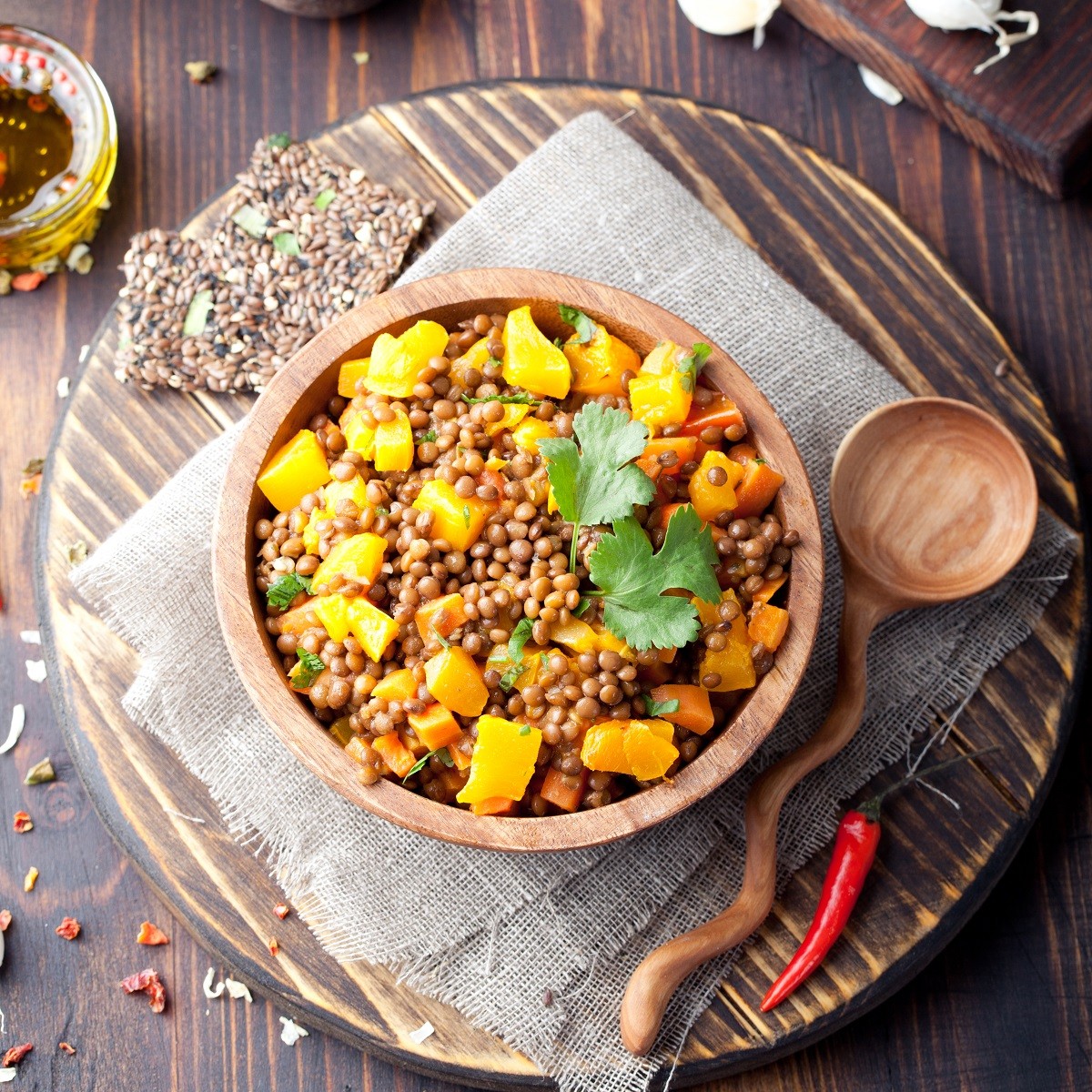 Lentil with carrot and pumpkin ragout in a wooden bowl.