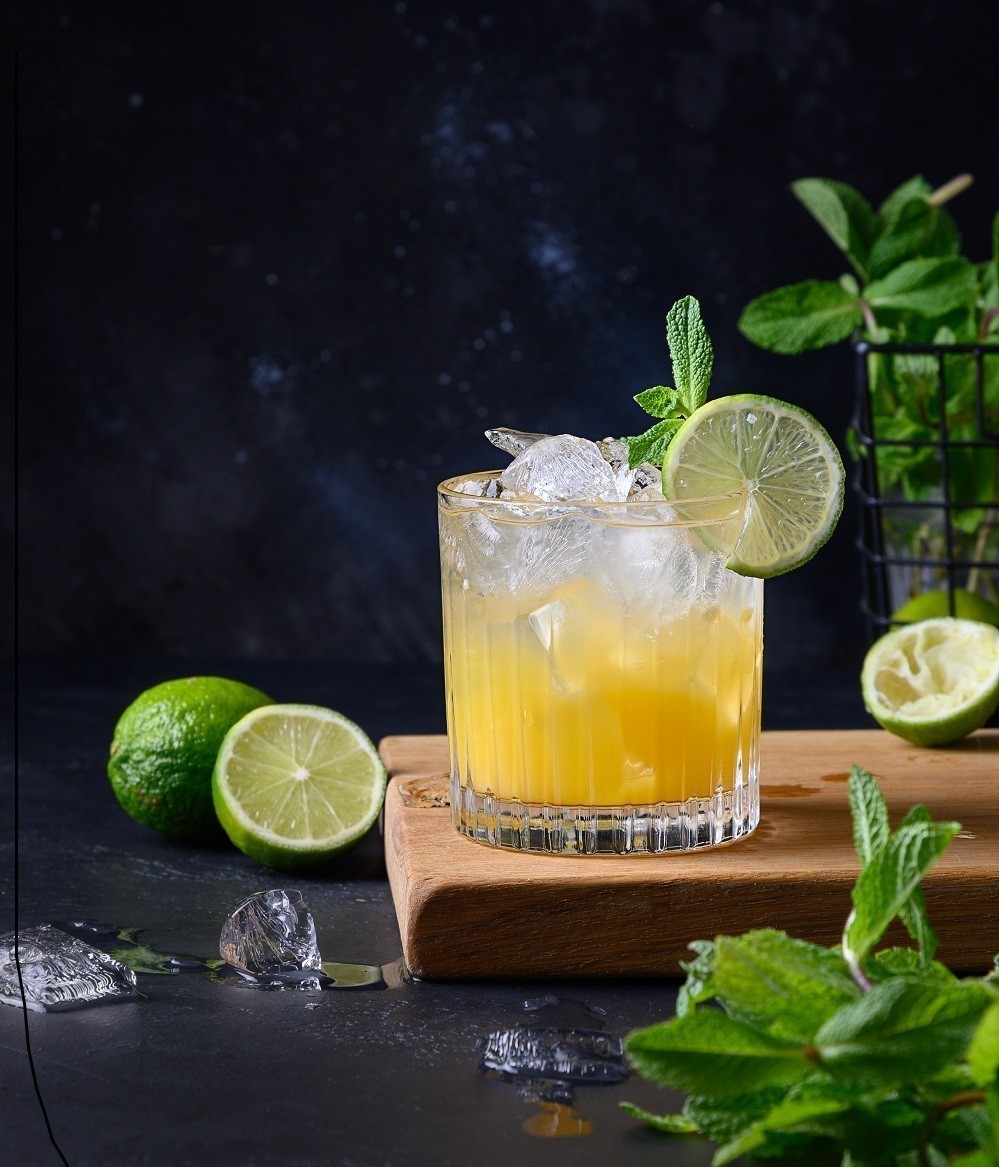 Freshness tropical lemonade with lime, orange and mint on black. Vertical format.