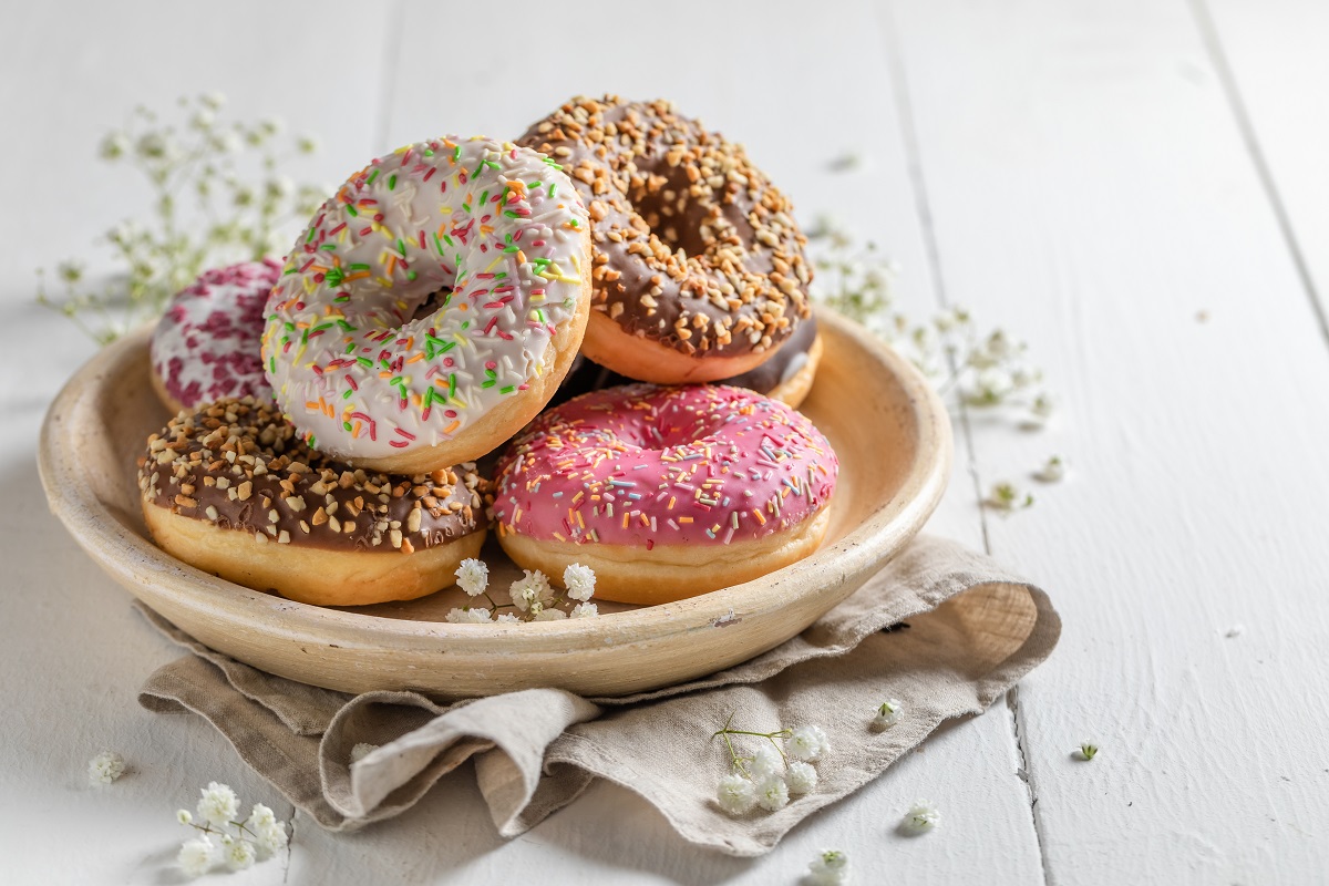 Yummy and fresh donuts on white wooden table
