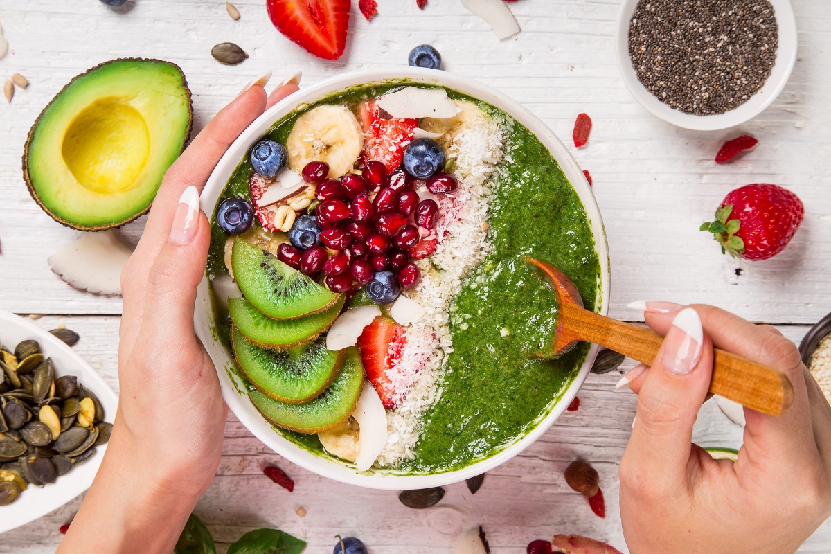 Smoothie bowl with fresh berries, nuts, seeds, fruit and vegetables.