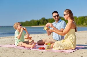 happy family having picnic on summer beach