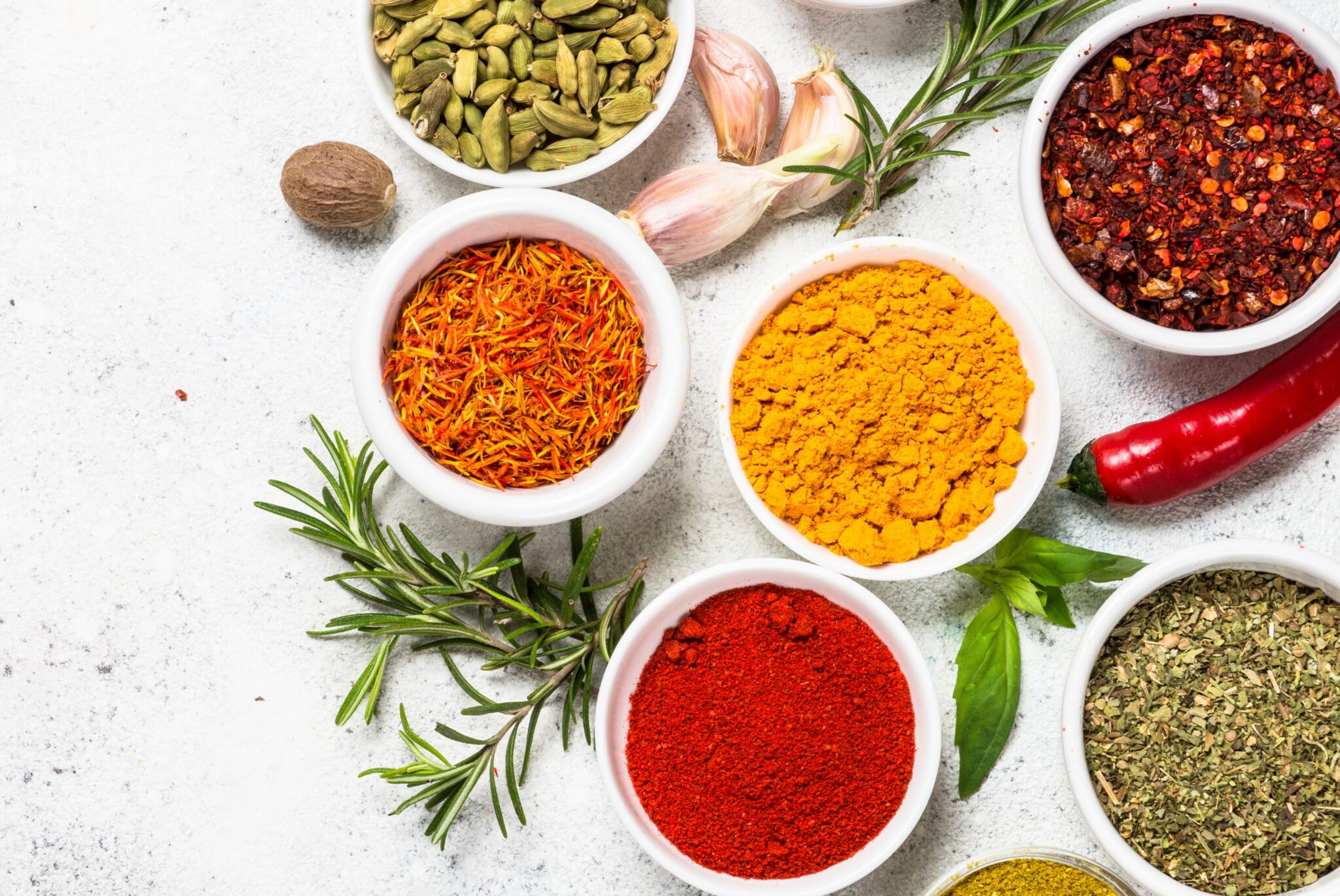 Spices and herbs on white stone table.