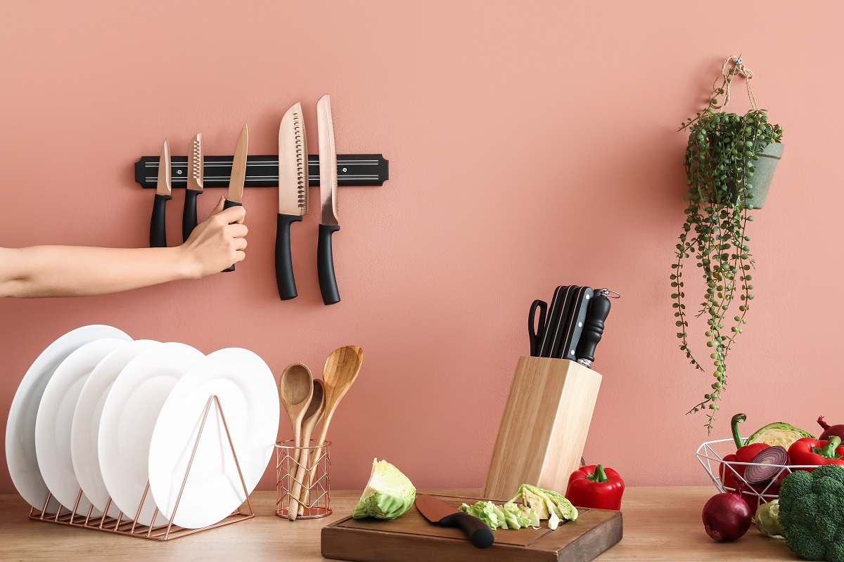 Woman with knives and vegetables in kitchen