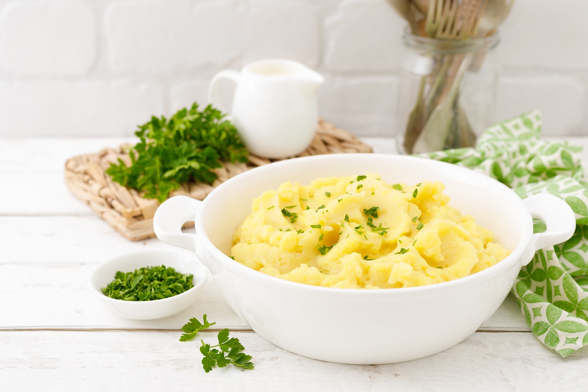 Mashed potato with butter and milk on table
